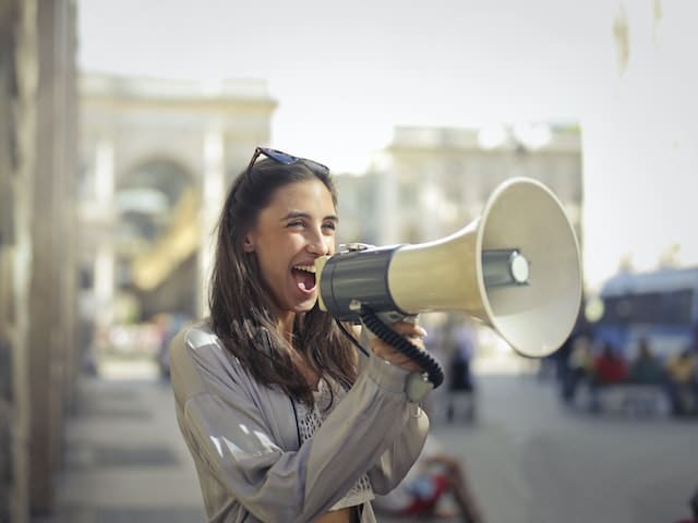 woman with megaphone in the streets promoting her business